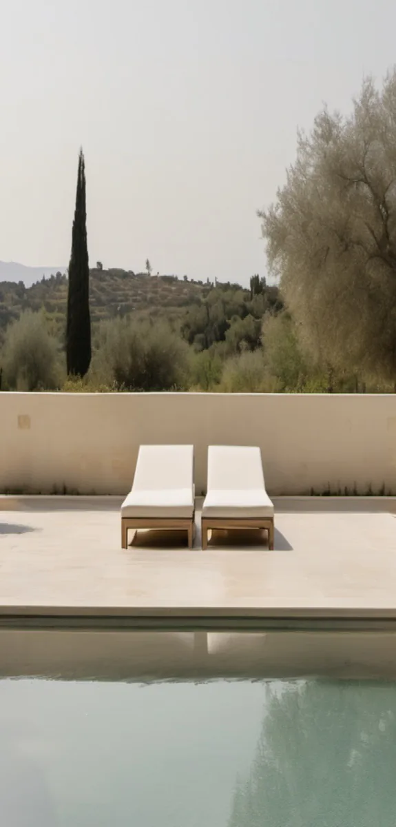 Two loungers at still water, a cypress and the hills beyond